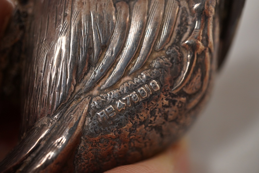 An Edwardian novelty silver mounted pin cushion, modelled as a duck, by Abrahall & Bint, engraved with 'feather' decoration and glass eyes, Birmingham, 1906, length 94mm, height 59mm(a.f.).